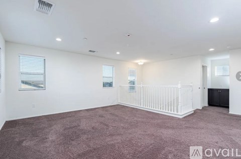 A spacious room with a white ceiling and a carpeted floor.