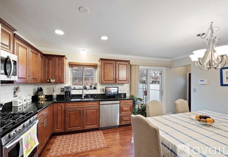 A kitchen with wooden cabinets and a black countertop.