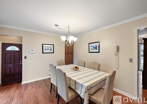 A dining room with a wooden table and chairs.