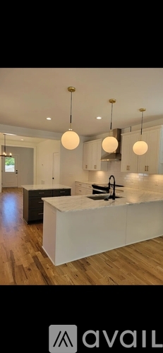 A modern kitchen with white cabinets and a central island.