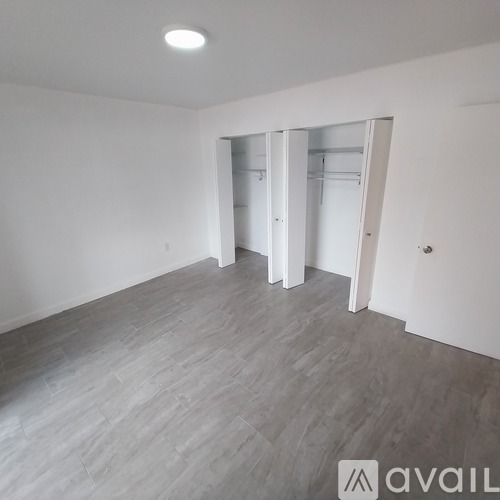 A spacious room with grey flooring and white walls.