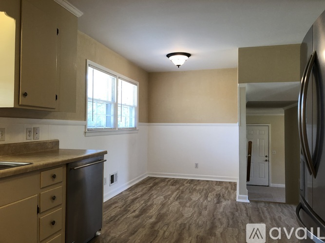 A kitchen with beige cabinets and a stainless steel dishwasher.
