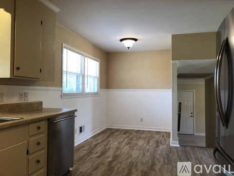 A kitchen with beige cabinets and a stainless steel dishwasher.