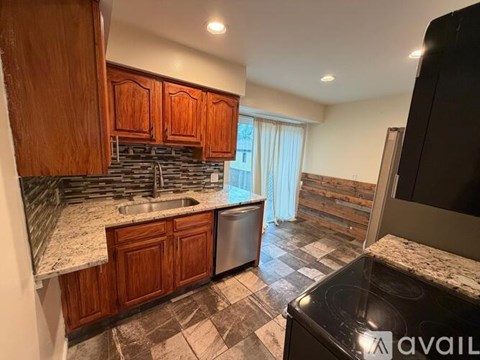 A kitchen with wooden cabinets and a black stove top oven.
