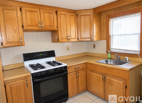 A kitchen with wooden cabinets and a black stove top oven.