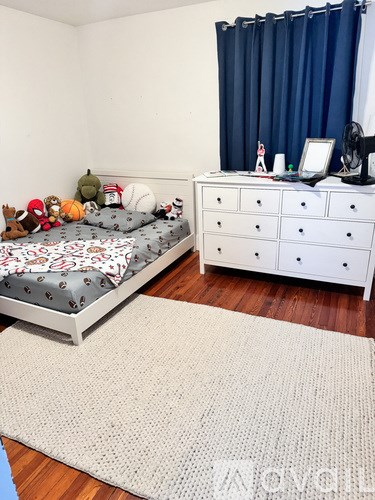 A bedroom with a bed, a dresser, and a rug.