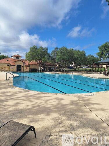 A swimming pool with a bench and trees in the background.
