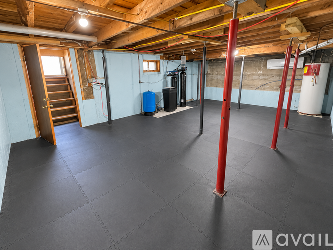 A spacious room with a grey floor and red poles.