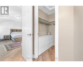 A bedroom with a bed and a rug is visible through an open door.