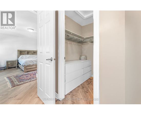 A bedroom with a bed and a rug is visible through an open door.