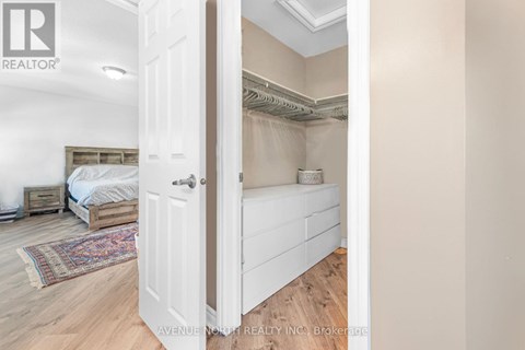 A bedroom with a bed and a rug is visible through an open door.