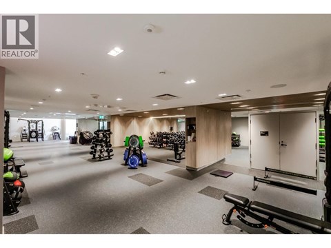 A gym with a variety of equipment including treadmills, stationary bikes, and weight machines.