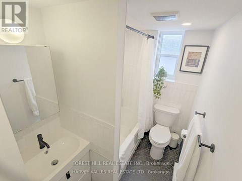 A white bathroom with a toilet, sink, and bathtub.