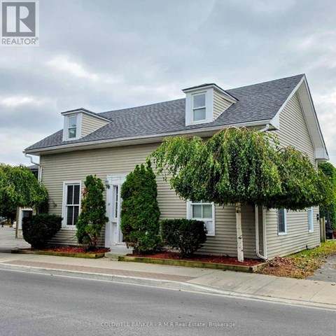 A house with a grey siding and a white door is shown.