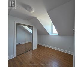 A room with wooden floors and a slanted ceiling.