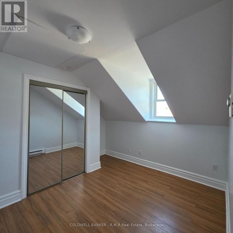 A room with wooden floors and a slanted ceiling.