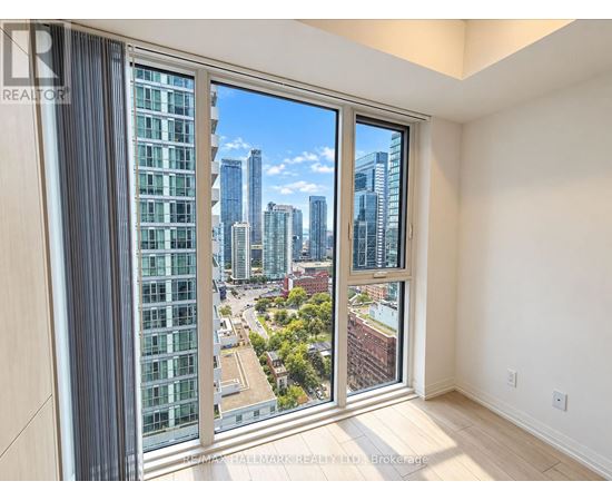 A room with a view of a city skyline through a large window.