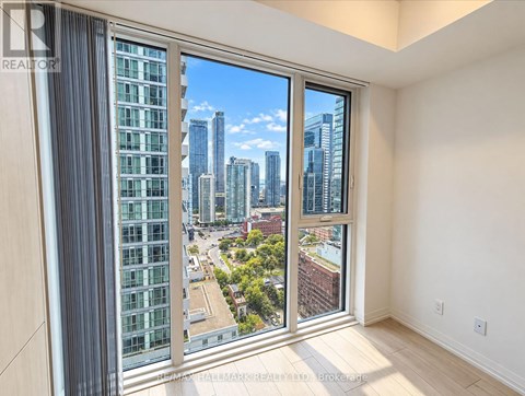 A room with a view of a city skyline through a large window.