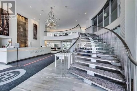 A staircase with a glass railing and a circular pattern on the floor.