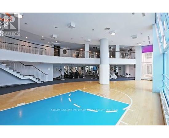 A basketball court in a spacious room with a balcony.
