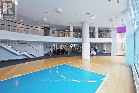 A basketball court in a spacious room with a balcony.
