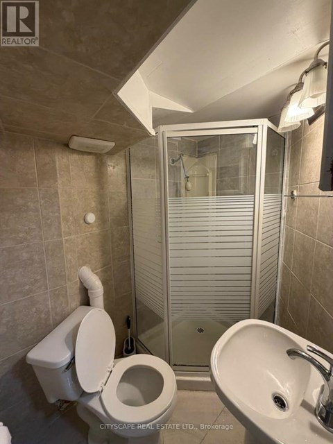 A bathroom with a toilet, sink, and shower.