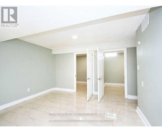 A spacious room with a doorway leading to another room.