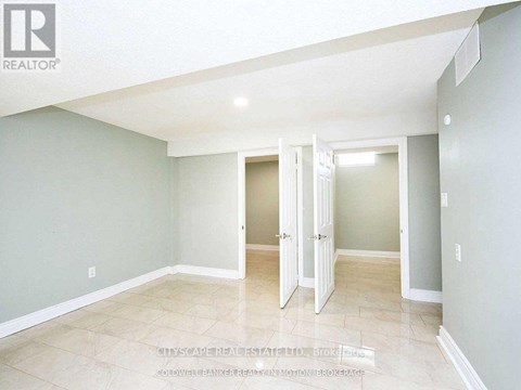 A spacious room with a doorway leading to another room.