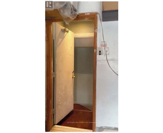 A small, unfinished room with a door and a window.