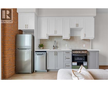 A kitchen with a refrigerator and a washing machine.