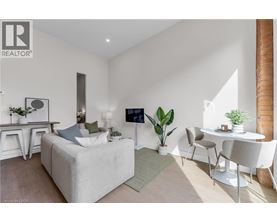 A modern living room with a white sofa, a white coffee table, and a white chair.
