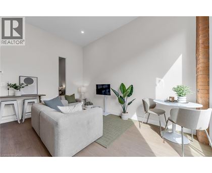 A modern living room with a white sofa, a white coffee table, and a white chair.