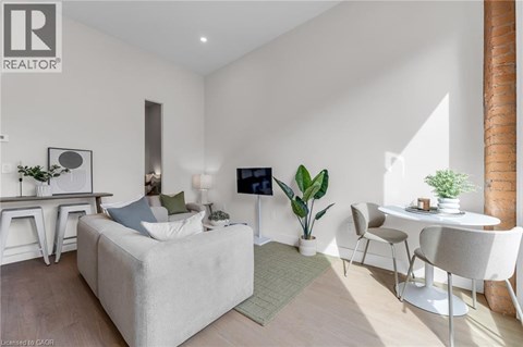 A modern living room with a white sofa, a white coffee table, and a white chair.