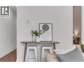 A living room with a white couch and a wooden table with a vase of flowers on it.