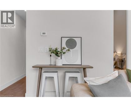 A living room with a white couch and a wooden table with a vase of flowers on it.