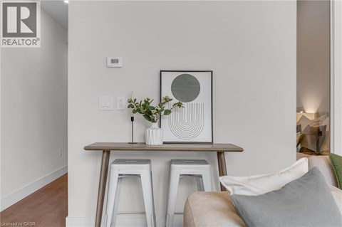 A living room with a white couch and a wooden table with a vase of flowers on it.