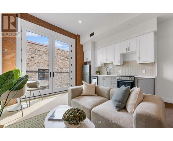 A living room with a couch, a chair, and a potted plant.