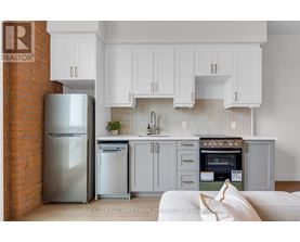 A modern kitchen with a stainless steel refrigerator and oven.