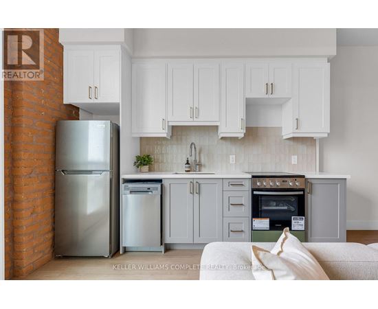 A modern kitchen with a stainless steel refrigerator and oven.