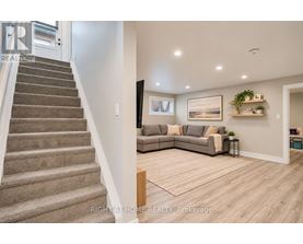 A living room with a couch, a chair, and a potted plant.