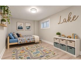 A bedroom with a bed, a rug, a wall-mounted shelf, and a wall-mounted light fixture.