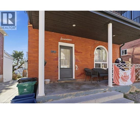 A red brick building with a black door and a sign that says Seventeen.