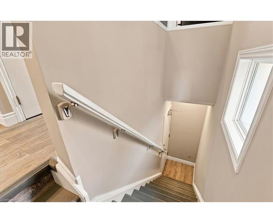 A staircase with a metal handrail and wooden steps.