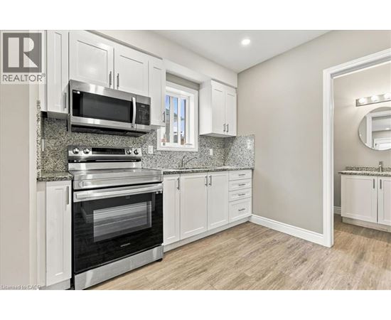 A modern kitchen with white cabinets and stainless steel appliances.