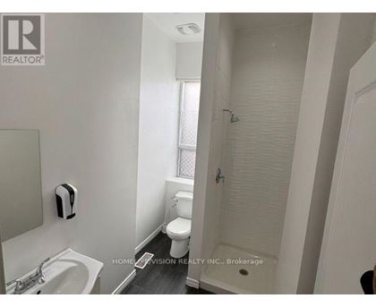 A white bathroom with a sink, toilet, and shower.