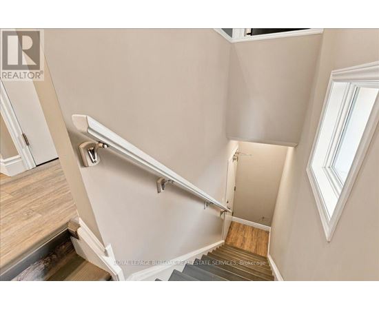 A staircase with a metal handrail and wooden steps.