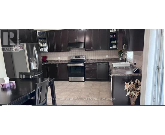 A kitchen with brown cabinets and a black counter top.