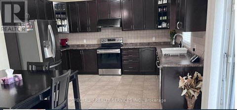A kitchen with brown cabinets and a black counter top.