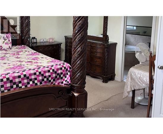A bedroom with a bed, dresser, and mirror.