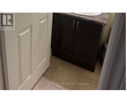 A bathroom with a white door and brown cabinets.